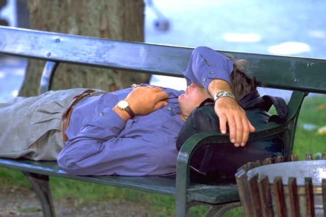 Ejecutivo dormido sobre un banco